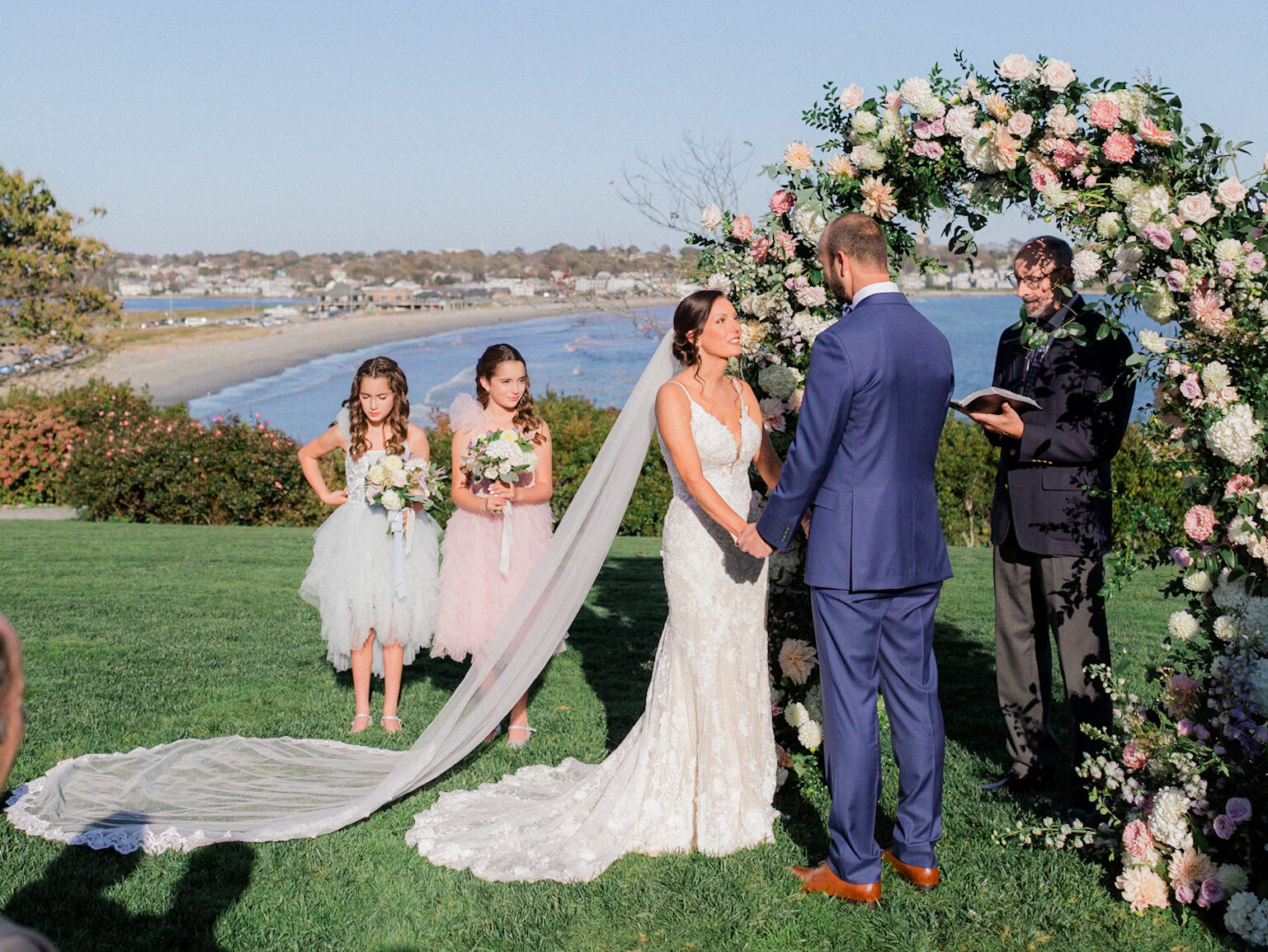 bride and groom standing at a wedding ceremony arch