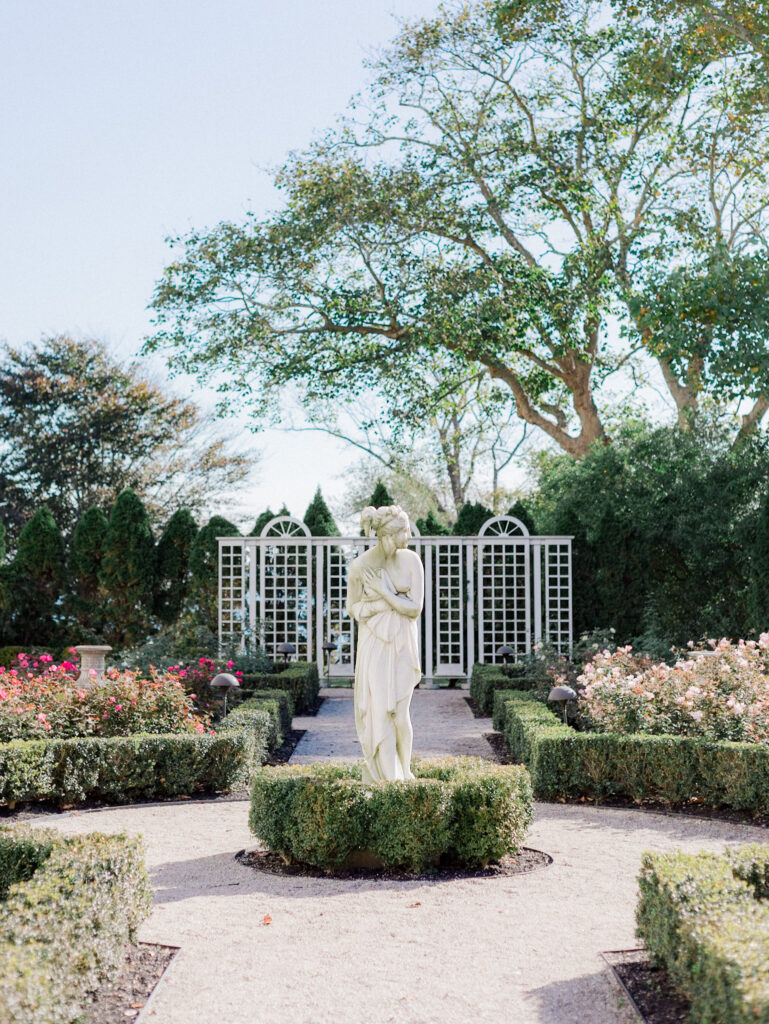 statue of a woman standing in the side garden of rosecliff mansion